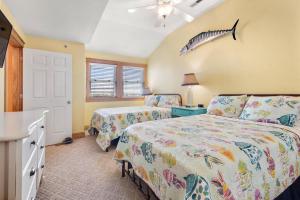 a bedroom with two beds and a fish on the wall at Look Out - The Landings at Sugar Creek in Nags Head +23 photos
