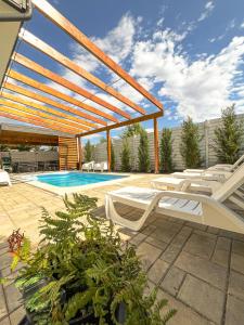 Un patio con tumbonas y una piscina. en AGrey frame Residence Villas, en Bucarest