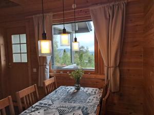 a dining room with a table and a window at Huipunpuisto B, sähköauton lataaminen sisältyy vuokraan in Syöte