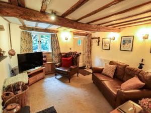 a living room with a couch and a tv at Fellside Cottage in Bowness-on-Windermere