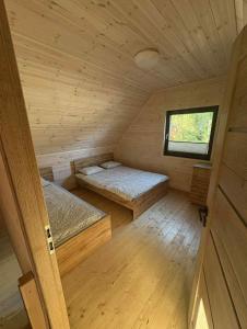 ein Zimmer mit zwei Betten in einer Holzhütte in der Unterkunft Szare Domki in Mrzeżyno
