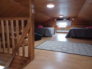 a attic room with two beds and a staircase at Huipunpuisto, Pikku-Syötteen huipulla, B-puoli in Syöte