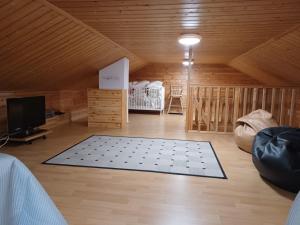 a room with a bed and a television in a attic at Huipunpuisto B, sähköauton lataaminen sisältyy vuokraan in Syöte