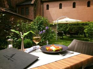 a table with a plate of food and a glass of wine at Logis Hôtel-Restaurant du Herrenstein in Neuwiller-lès-Saverne
