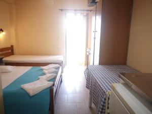 a room with two beds and a window at Psarou Thalassa Studios in Amoudi