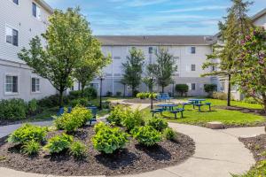 a building with a courtyard with tables and benches at Studio 6 Toronto - Mississauga with Kitchenettes in Mississauga