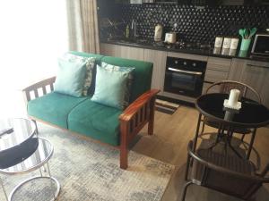 内罗毕Rustic Like Studio Next To Pride Inn & Ibis Hotels Westlands的客厅里有一张绿色的沙发和一张桌子