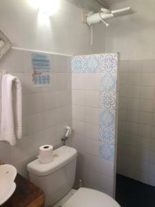 a white bathroom with a toilet and a sink at Pousada Casa da Praia Itaúnas in Itaúnas +60 photos