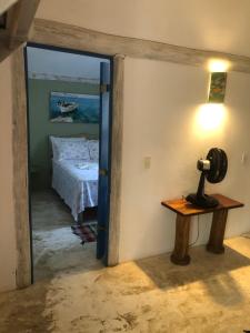 a room with a bed and a lamp on a table at Pousada Casa da Praia Itaúnas in Itaúnas