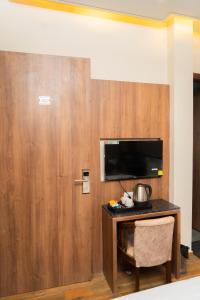 a room with a wooden door with a table and a chair at Hotel RK Heights 300M HOTEL TO GOLDEN TEMPLE in Amritsar +17 photos