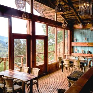 a dining room with tables and chairs and windows at Hotel Boutique y Cabañas Alto de la Sierra in San Mateo Río Hondo