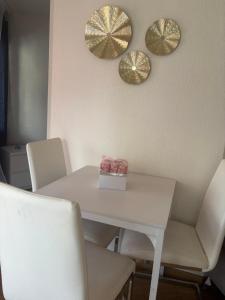 une table blanche avec des chaises blanches et deux miroirs au mur dans l'établissement AptBlue, à Ostermundigen