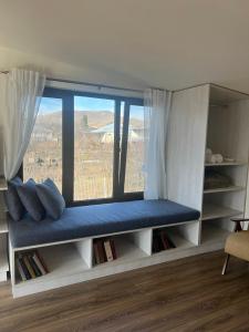 a window seat in a room with a large window at Green Agarak 2 near Dendropark, Stepanavan in Gyulagarak