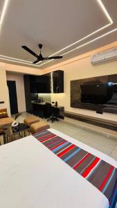 a living room with a bed and a flat screen tv at Chalo Chaley Luxury Stays in Ghaziabad +1 photo