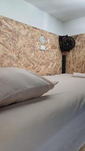 a close up of a bed with a pillow at Green Belly Surf Hostel in El Paredón Buena Vista