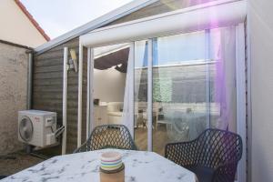 a balcony with a table and chairs and a bathroom at La Deniserie - Proche Beauval & Chambord - Garage Privé in Romorantin