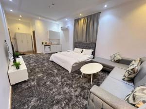 a bedroom with a bed and a couch and a table at A privet room in AL Rawda in Quai