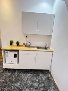 a kitchen with white cabinets and a sink at A privet room in AL Rawda in Quai