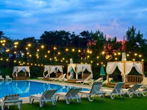 a pool at night with chairs and lights at Hotel Aeetes Kobuleti in Kobuleti