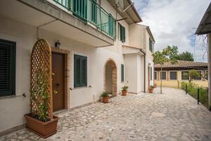 a courtyard of a house with potted plants on it at Grappolo B&B affittacamere in Ascea