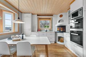 a white kitchen with a white table and chairs at Whole Holiday Home in Asker +7 photos