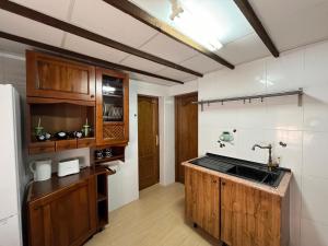 a kitchen with wooden cabinets and a sink at Villa Alcázar in San Pedro del Pinatar