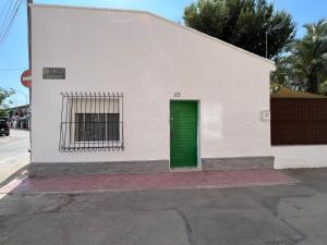 a white building with a green door on a street at Villa Alcázar in San Pedro del Pinatar