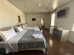 Un dormitorio con una cama grande con flores. en Pousada Casarão Schmidt, en Pomerode 35 fotos más