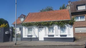 门兴格拉德巴赫Kleines, gemütliches Häuschen的街上有红色屋顶的白色房子