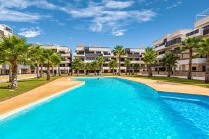 a swimming pool with palm trees in front of apartments at Casa Azul in La Florida