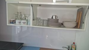 a kitchen cabinet with plates and dishes on it at WOHLFÜHLOASE - Zimmer, Appartment - im Herzen STARNBERGS in Starnberg