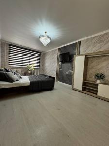 Un dormitorio con una cama grande y una lámpara de araña. en Апартаменты на Калдаякова, en Shymkent