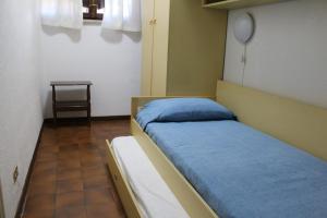 a hospital room with a bed with blue sheets at Casa Giò in Brusimpiano