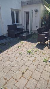 a patio with two chairs and a table and a building at WOHLFÜHLOASE - Zimmer, Appartment - im Herzen STARNBERGS in Starnberg