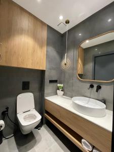 a bathroom with a toilet and a sink and a mirror at Bamboo Beach Tsikhisdziri, Solmare Loft in Itʼkhvisi +10 photos