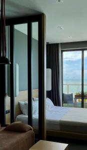 a bedroom with a bed and a view of the ocean at Bamboo Beach Tsikhisdziri, Solmare Loft in Itʼkhvisi