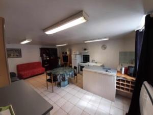 a kitchen and a living room with a red couch at Gite saint marc in Mer