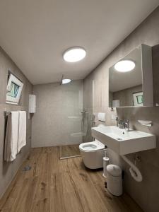 a bathroom with a sink and a toilet and a mirror at Apartmani Krsto in Kravlja +4 photos