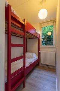 Un dormitorio con dos literas y una ventana. en Natuurhuisje Ees, en Ees