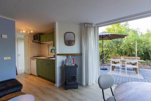 a kitchen and living room with a table and a kitchen and a dining room at Natuurhuisje Ees in Ees
