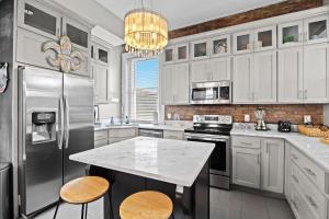 Una cocina con gabinetes blancos y una encimera blanca. en Historic 3-BR Downtown Bourbon Getaway, en Louisville