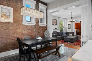 comedor y sala de estar con pared de ladrillo en Historic 3-BR Downtown Bourbon Getaway, en Louisville