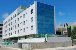 a large white building with glass windows at Hotel Green Sunset 407 in João Pessoa