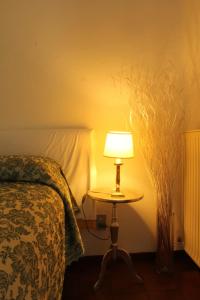 a bedroom with a bed and a table with a lamp at Casa Giò in Brusimpiano