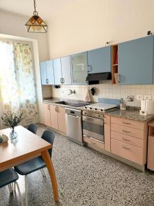 a kitchen with blue cabinets and a table with chairs at La Finestra sul Blu - Sea View in Savona