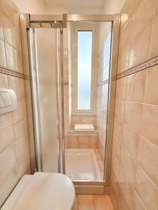 a shower in a bathroom with a toilet and a window at La Finestra sul Blu - Sea View in Savona +24 photos