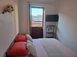 ポルト・トッレスにあるCentro mare residence affitta alloggiのベッドルーム1室(赤い枕のベッド1台、窓付)