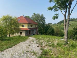 an old house with a red roof on a field at Romantisches Tiny House mit Pool and Air Condition in Tržec +29 photos