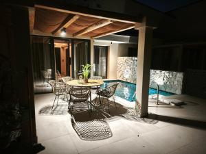a patio with a table and chairs next to a pool at Elaida suites in Prinos