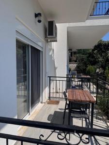 Il dispose d'une terrasse couverte avec une table et des chaises en bois. dans l'établissement VILLA MYRTAJ, à Saranda
